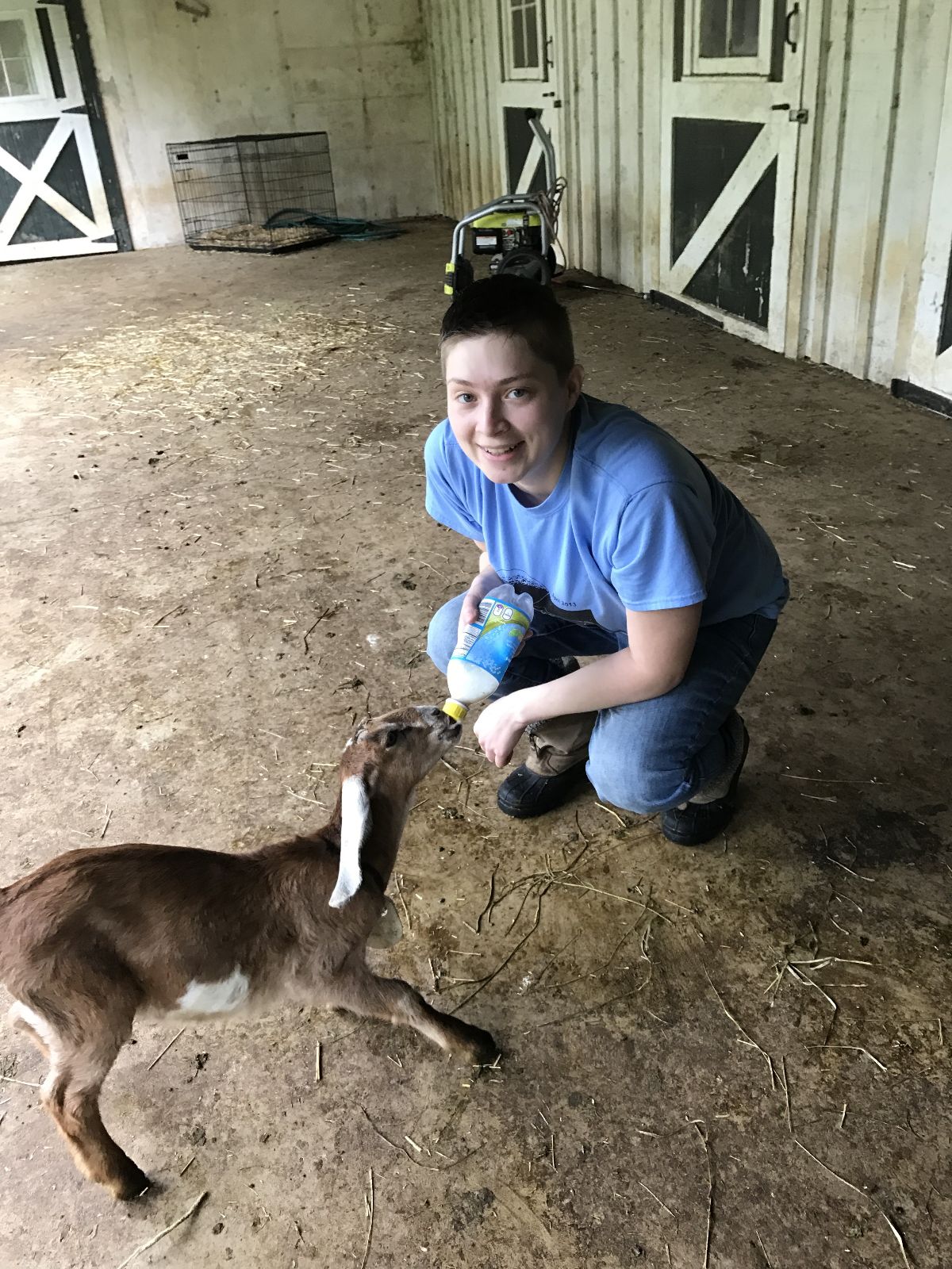 Liz feeding a baby goat with a bottle