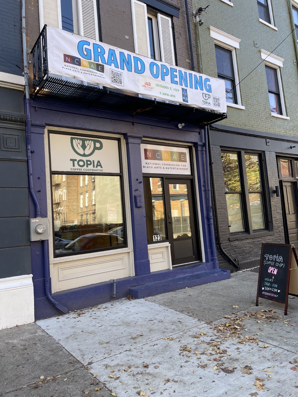 Topia storefront with "grand opening" sign